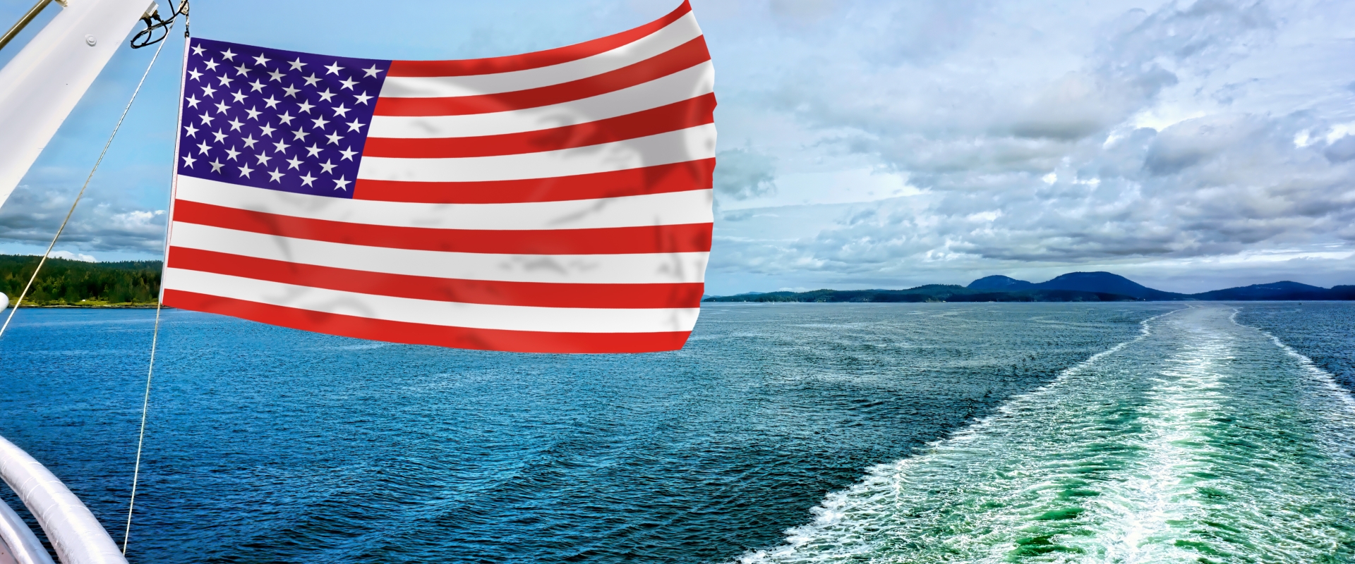 Patriotic shot of American flag billowing over the sea
